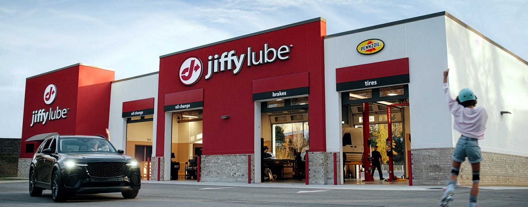A car pulling out of a Jiffy Lube location bay