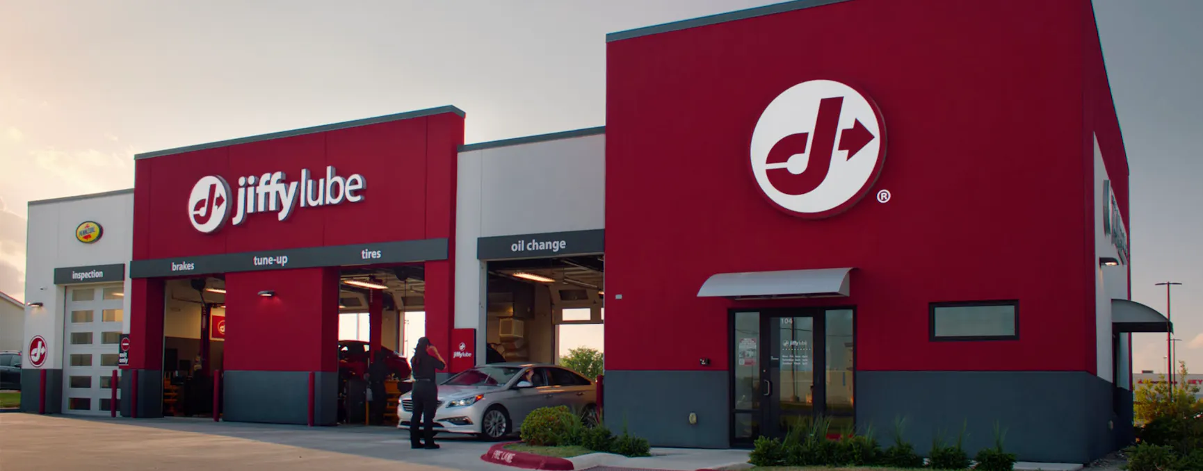 A car pulling out of a Jiffy Lube location bay